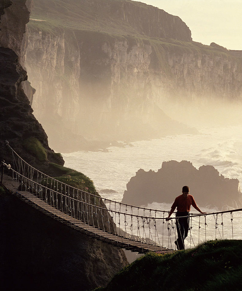 Man Crossing Rope Bridge, Coast of Ireland